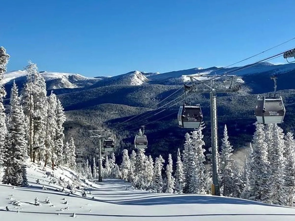 An awe-inspiring exterior view of a gondola lift suspended amid snow-covered trees, with a sweeping mountain landscape in the background. The setting is tranquil yet adventurous, evoking the thrill of mountain exploration and easy access to world-class slopes.